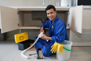 Desentupidor da DF sorrindo, cumprindo serviço com aparelhos - desentupimento de pia residencial - profissionais - Desentupidora em Brasília 24 horas
